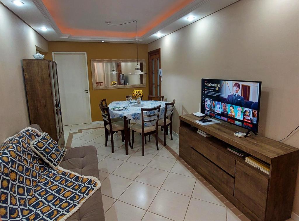 sala de estar con mesa de comedor y TV en Apartamento Completo 2 Quartos Wi-Fi 300 Mbps, en Porto Alegre