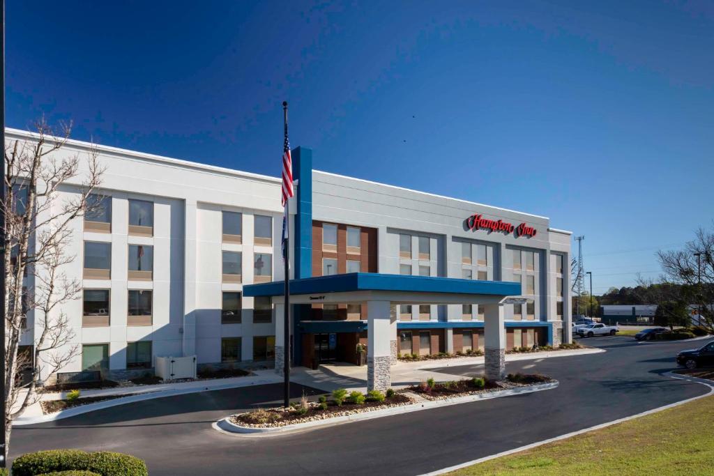 un immeuble de bureaux doté d'un drapeau américain devant lui dans l'établissement Hampton Inn Conyers, à Conyers