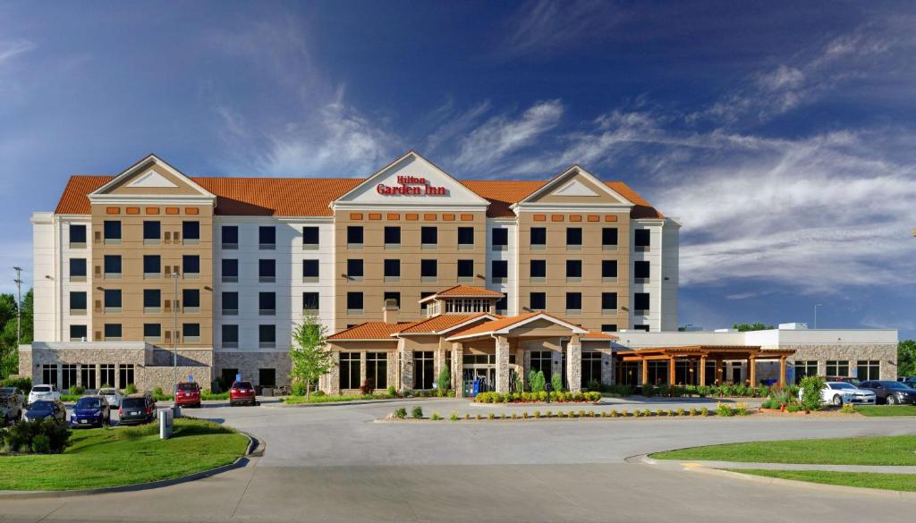 een hotel met een groot gebouw met een parkeerplaats bij Hilton Garden Inn Springfield, MO in Springfield