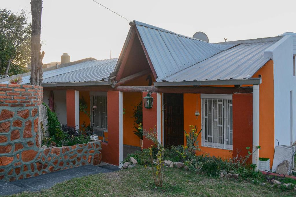 ein orange-weißes Haus mit einer Backsteinmauer in der Unterkunft CASA LA QUEBRADA in Cordoba