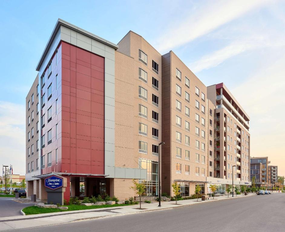 un edificio alto rojo en una calle de la ciudad en Hampton Inn & Suites By Hilton Quebec City /Saint-Romuald, en Lévis