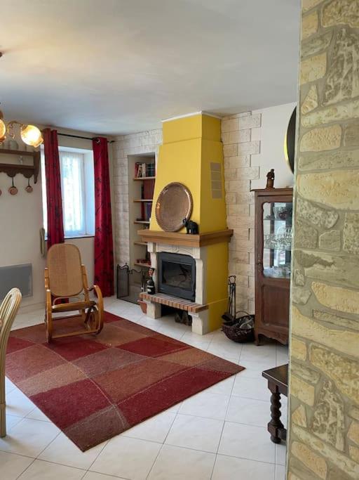 - un salon avec une cheminée jaune et une chaise dans l'établissement Family friendly house in Brenac, à Quillan