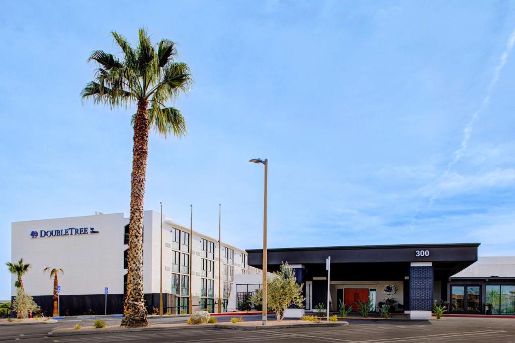 a building with a palm tree in a parking lot at Doubletree By Hilton Palmdale, Ca in Palmdale