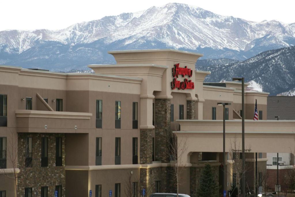 a hotel with a hotel sign in front of a mountain at Hampton Inn & Suites Colorado Springs-Air Force Academy/I-25 North in Colorado Springs