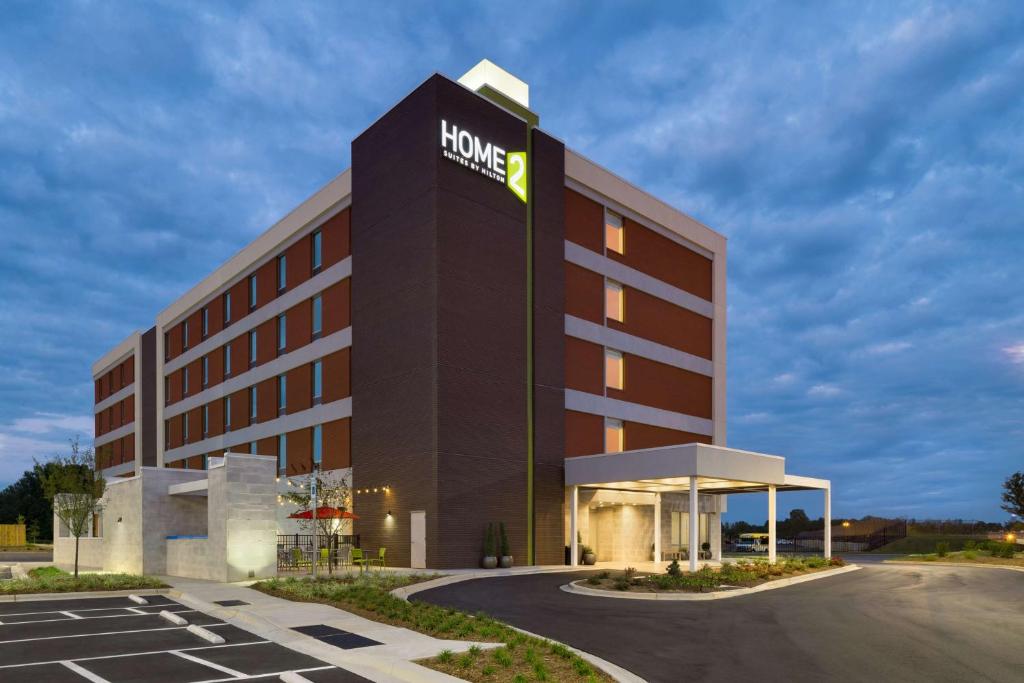 a hotel with a sign on the side of a building at Home2 Suites by Hilton Charlotte Airport in Charlotte