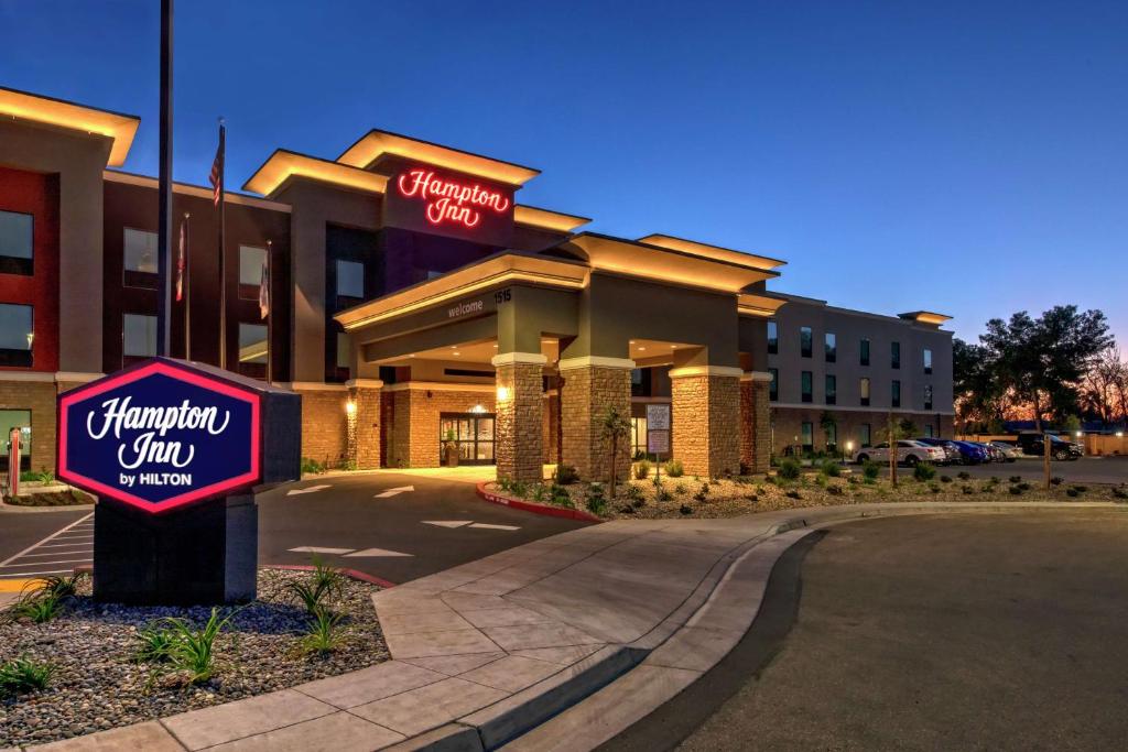 a hotel with a sign in front of it at Hampton Inn Fresno Airport in Fresno