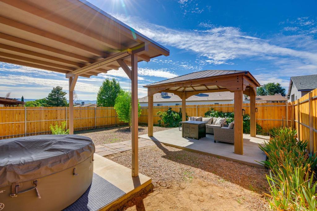 Prescott Valley Retreat with Private Hot Tub! في بريسكوت فالي: بريغولا خشبي مع سرير في الفناء الخلفي