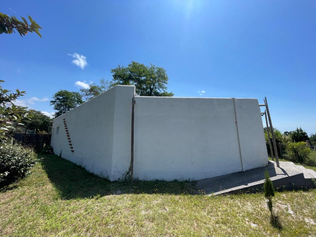 a white wall sitting on the side of a field at La Casba 15 mm plage Contis in Lévignacq