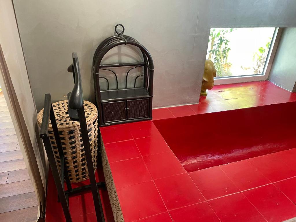 a red tile floor in a room with a chair at La Casba 15 mm plage Contis in Lévignacq