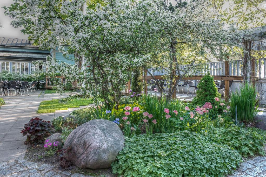 un jardín con flores y una roca grande en Motel Marine, en Tammisaari