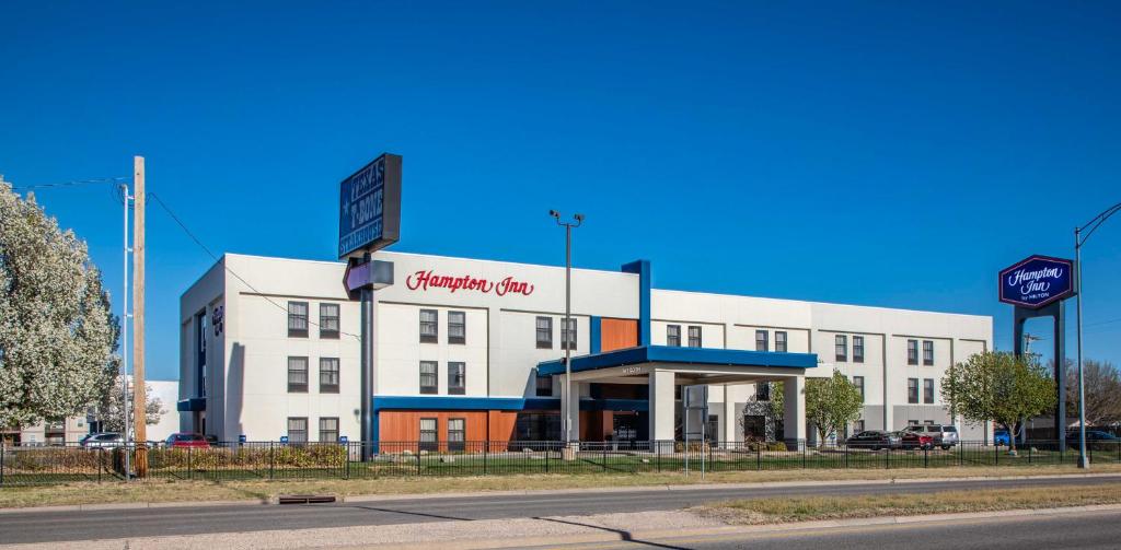 a white building with a sign on the side of it at Hampton Inn Hutchinson in Hutchinson
