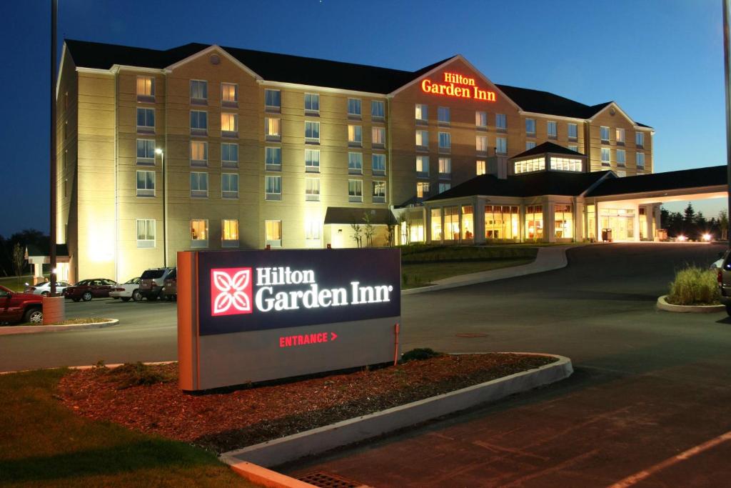 un cartel frente a una posada con jardín en Hilton Garden Inn Halifax Airport en Enfield