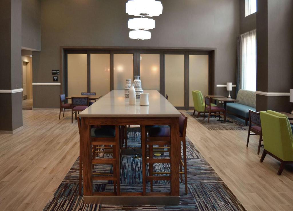 Hampton Inn & Suites Philadelphia/Media في ميديا: لوبي مع طاولة وكراسي في غرفة