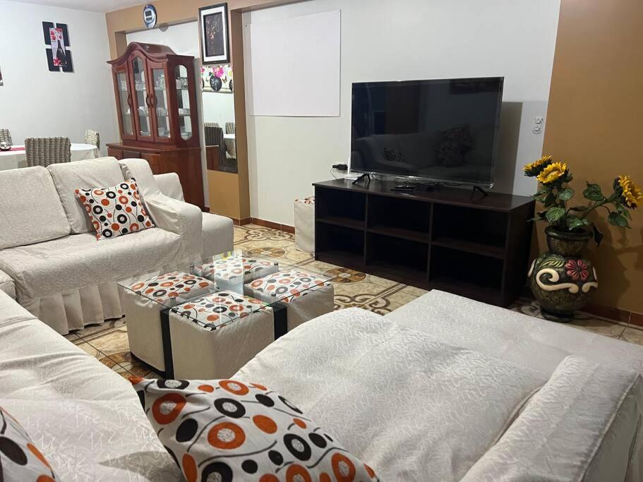 a living room with couches and a flat screen tv at Cuzco A 5 min del centro histórico¡Apartamento completo! in Cusco