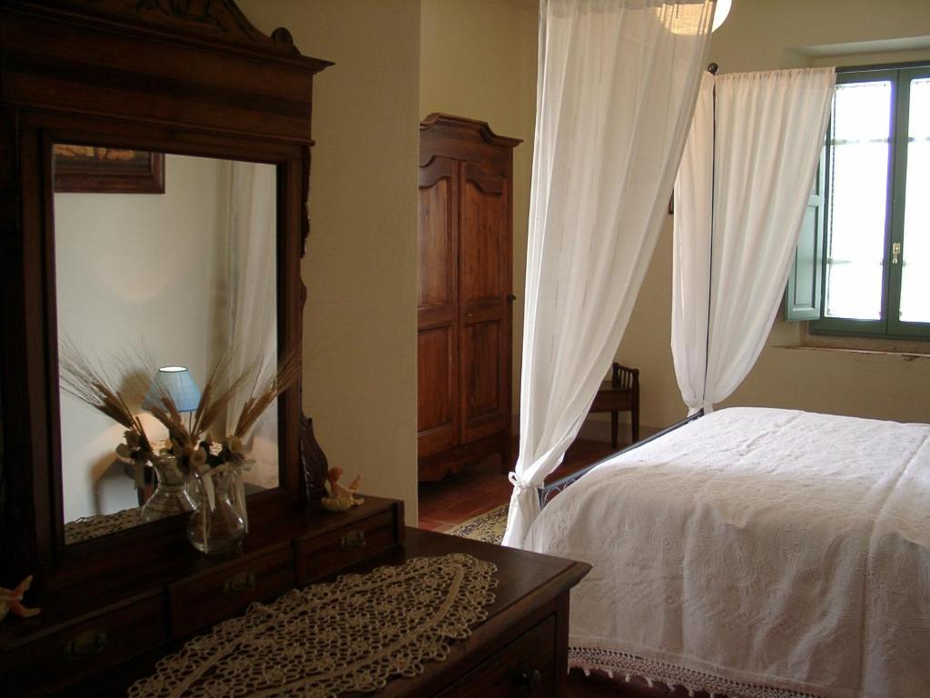 a bedroom with a bed and a dresser and a mirror at Agriturismo La Capitata in Pian di Scò