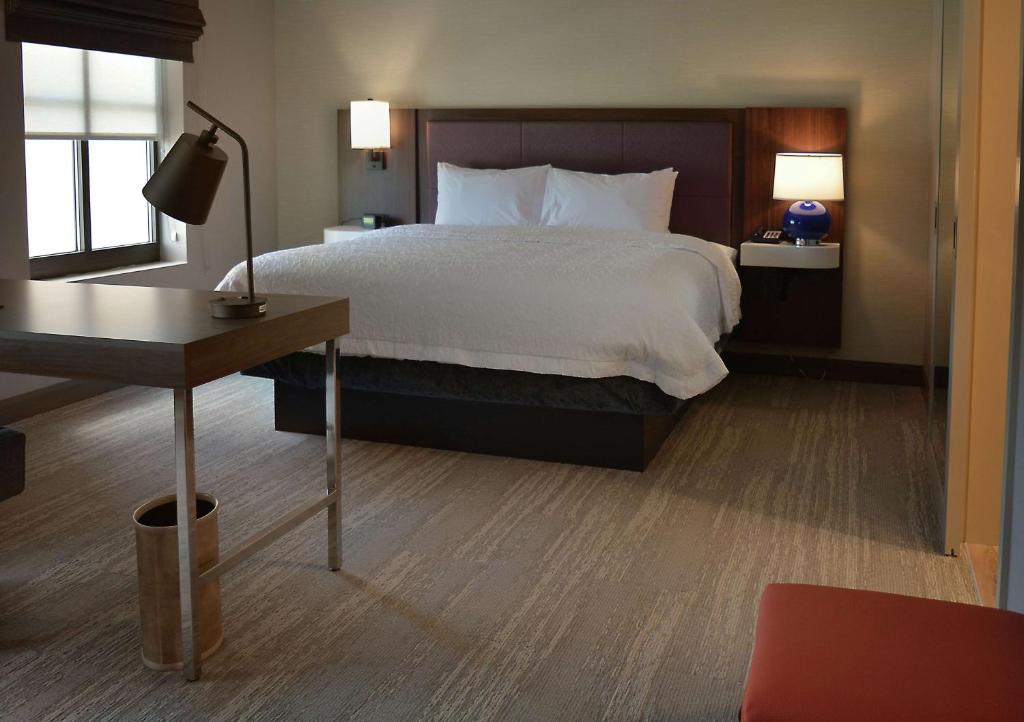 a bedroom with a large bed with a desk and a bed sidx sidx at Hampton Inn & Suites Philadelphia/Media in Media