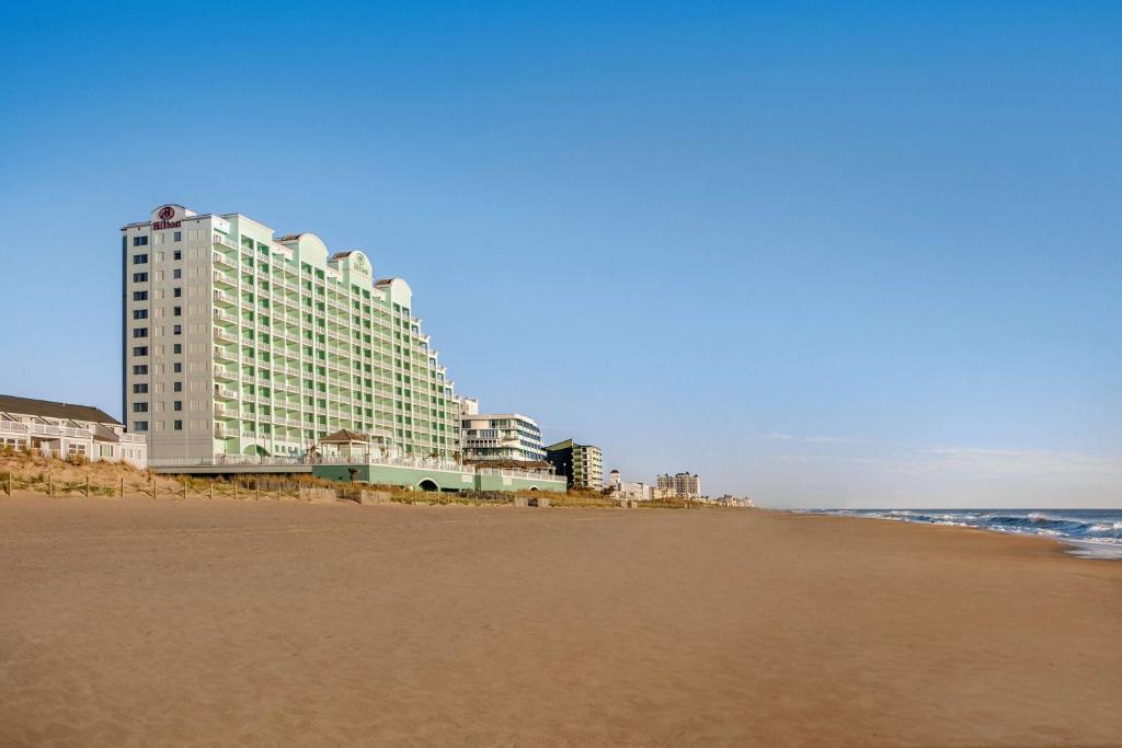 ein großes Gebäude am Strand mit dem Meer in der Unterkunft Hilton Suites Ocean City Oceanfront in Ocean City