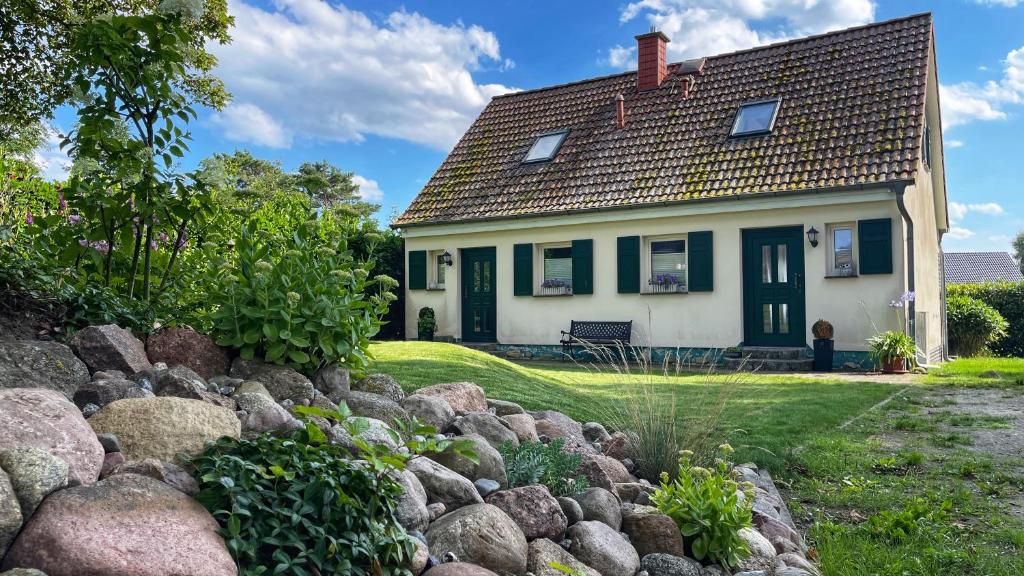 une maison avec un jardin en pierre en face dans l'établissement Ferienwohnung 1011 mit Seeblick, à Ziemitz