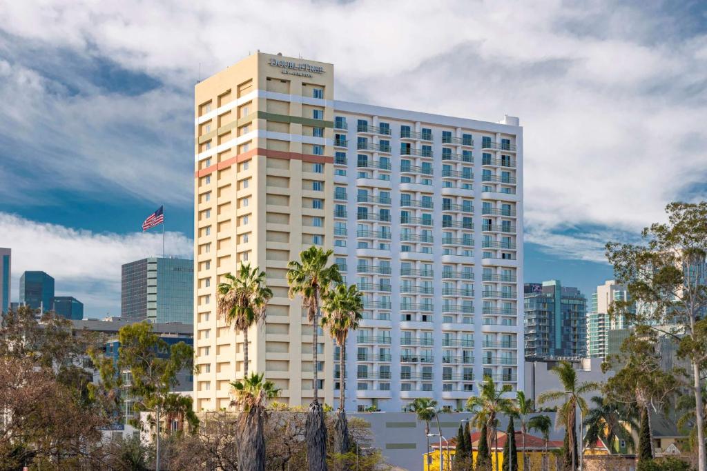 a tall white building with palm trees in front of a city at DoubleTree by Hilton San Diego Downtown in San Diego