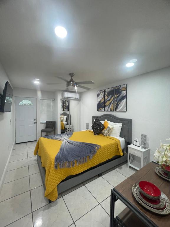 een slaapkamer met een geel bed en een tafel bij tranquilo y fantastico apartamento cerca de playas y areopuerto in Tampa