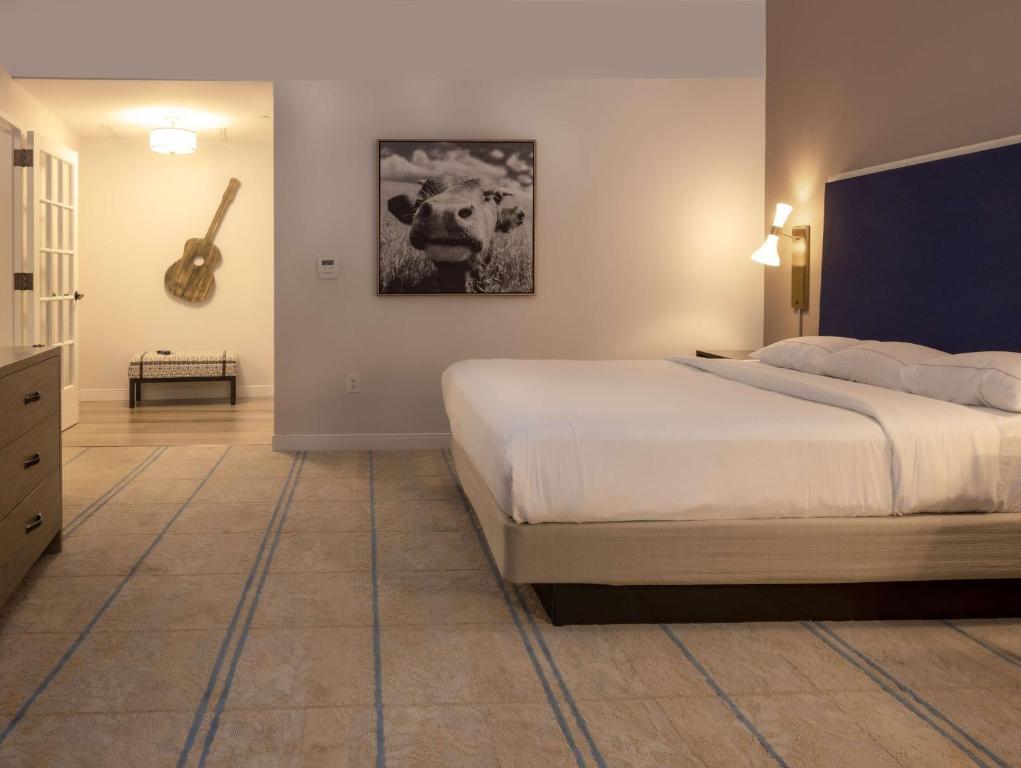 a bedroom with a bed and a guitar on the wall at Hilton Austin Airport in Austin