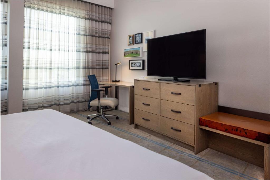 a bedroom with a bed and a television on a dresser at Hilton Austin Airport in Austin