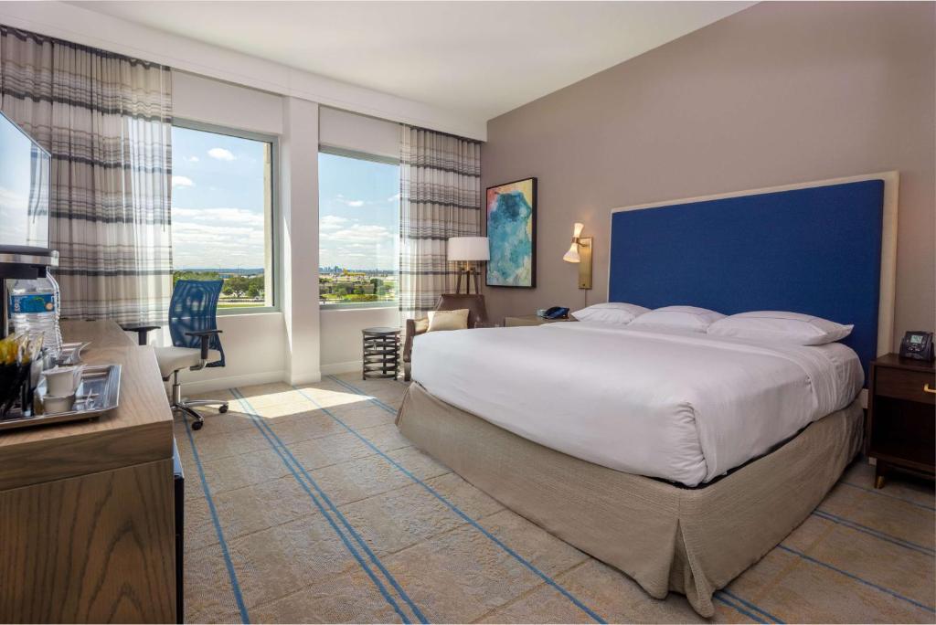 a bedroom with a large bed and a large window at Hilton Austin Airport in Austin