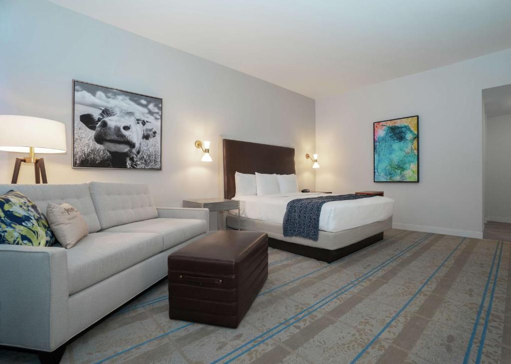 a hotel room with a bed and a couch at Hilton Austin Airport in Austin