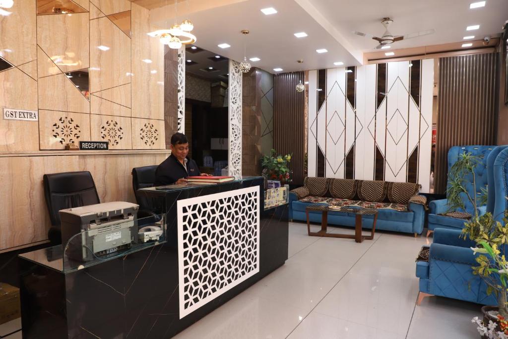 a man sitting at a desk in a lobby at Hotel Mittal Inn in Ajmer