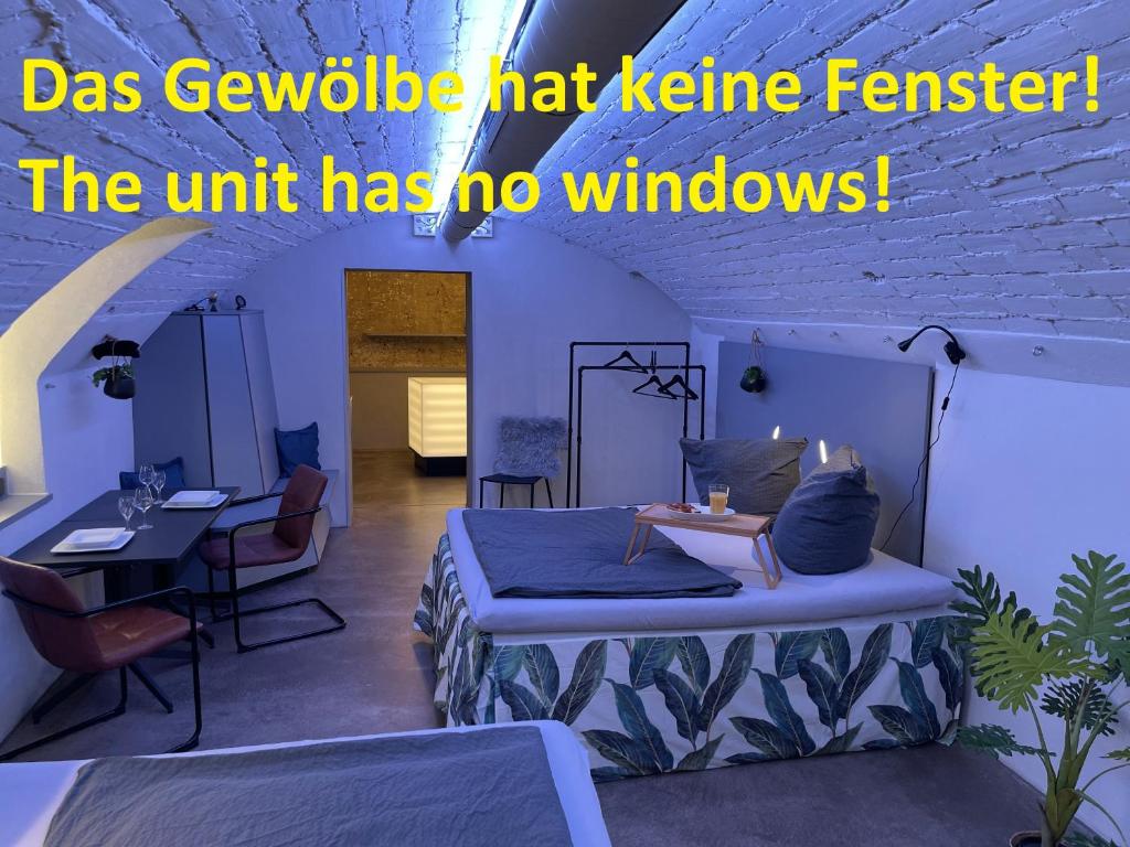 una camera con due letti e un tavolo con sedie di Soulfactory Apartments a Neu-Ulm