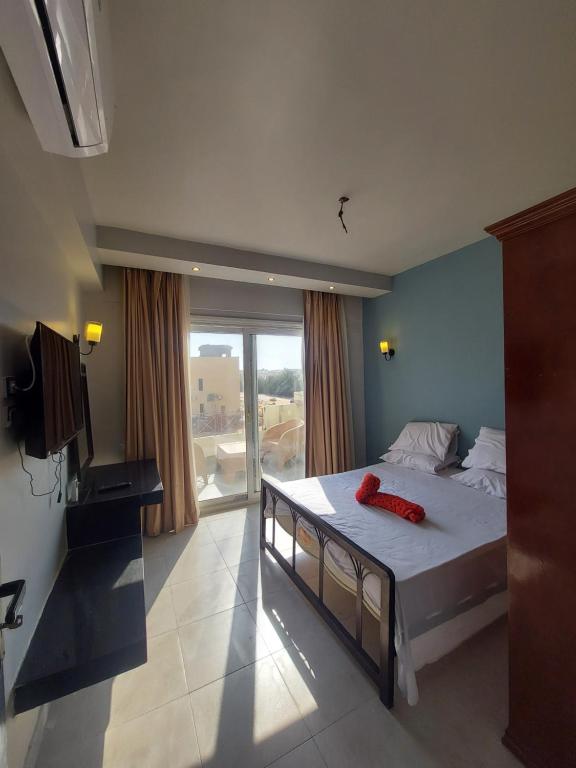 a bedroom with a bed and a large window at La Perla Resort Ras Sudr in Ras Sedr