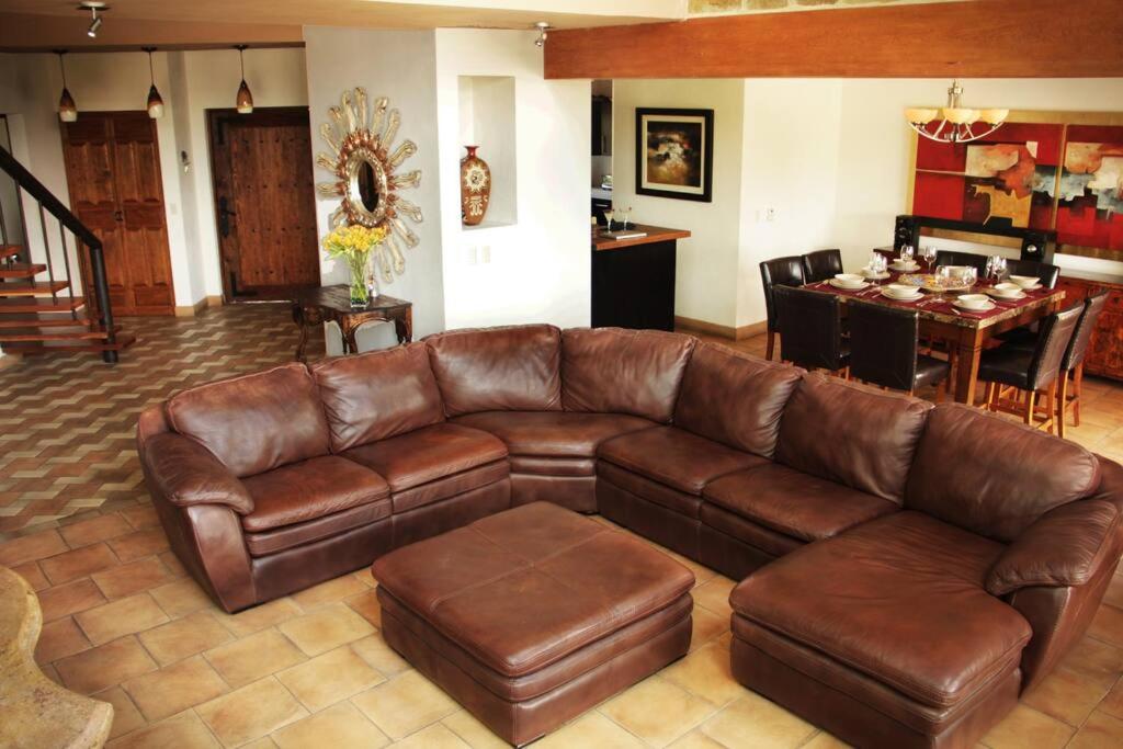een woonkamer met een bruine leren bank en een tafel bij Luxury at a great price in San Miguel in San Miguel de Allende