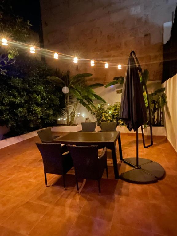 eine Terrasse mit einem Tisch, Stühlen und einem Sonnenschirm in der Unterkunft Casa de Limon in Palma de Mallorca