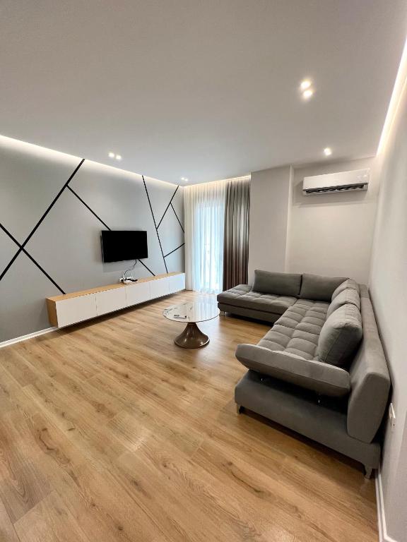 a living room with a couch and a flat screen tv at George apartments2023 in Korçë