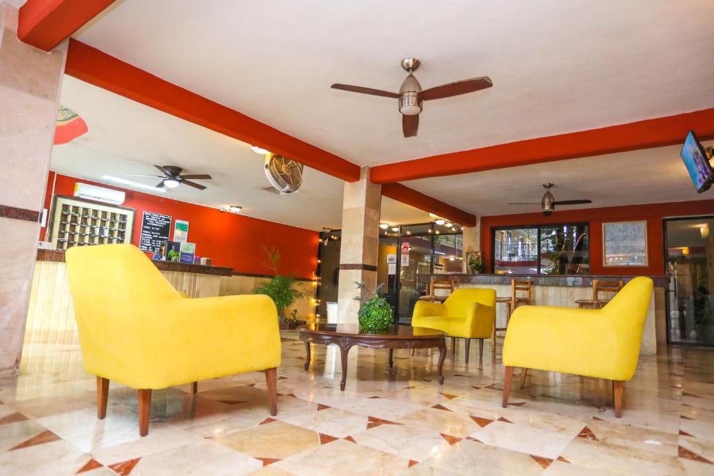 a restaurant with yellow chairs and a bar at Hotel Santa Maria in Cancún