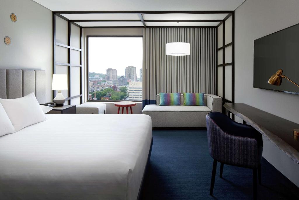 モントリオールにあるDoubleTree By Hilton Montrealのベッドと大きな窓が備わるホテルルームです。