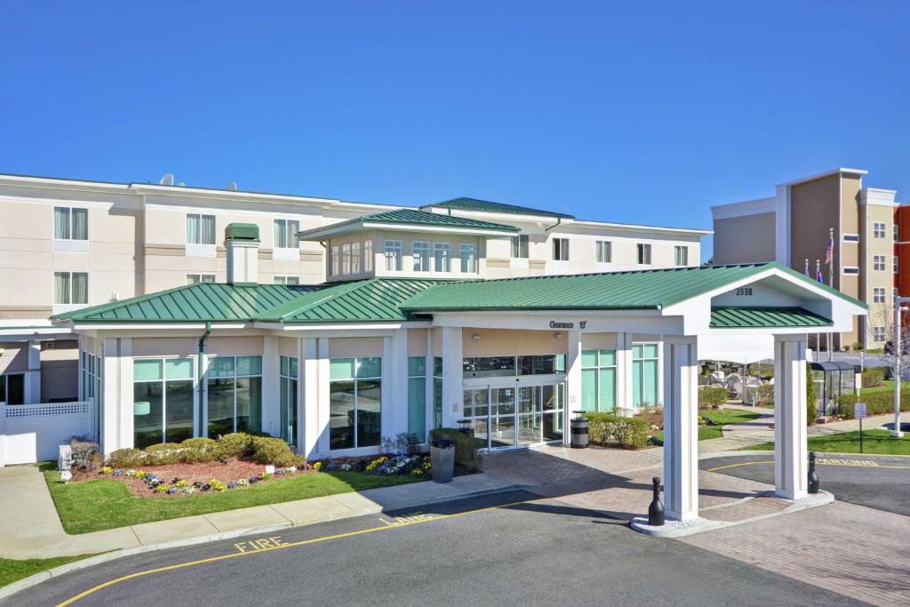 a building with a green roof in front of a street at Hilton Garden Inn Riverhead in Riverhead