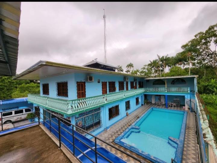 a large blue house with a swimming pool at Hotel Alto Amazonas in Leticia