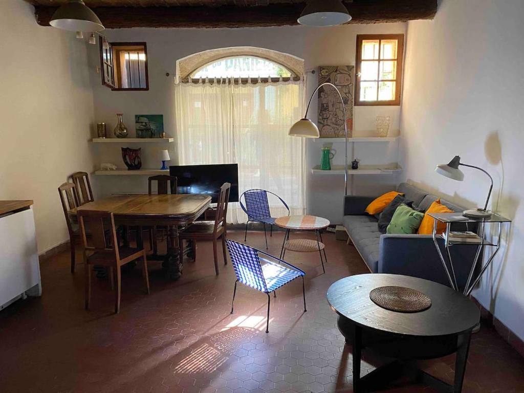 uma sala de estar com um sofá, uma mesa e cadeiras em Chez Serge em Marselha