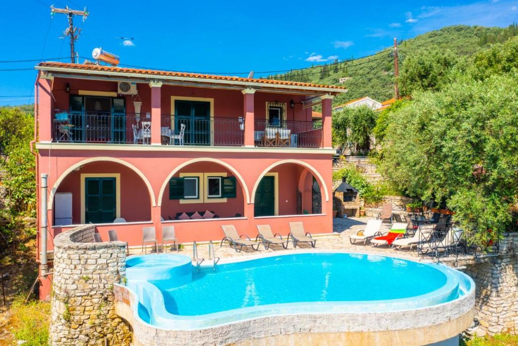 a villa with a swimming pool in front of a house at Bougainvillea in Gimari