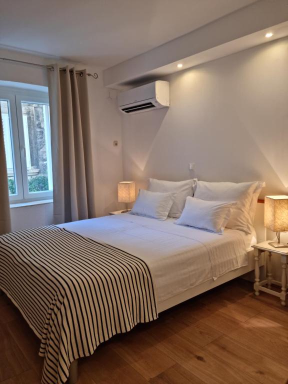 ein Schlafzimmer mit einem Bett mit gestreifter Decke in der Unterkunft Studio Riva in Hvar