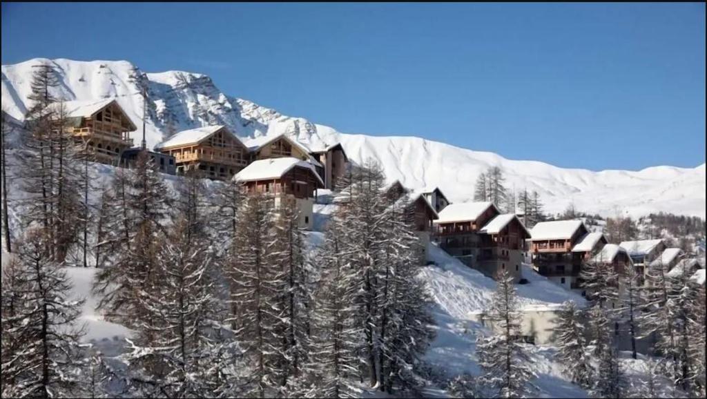 un complexe dans les montagnes couvertes de neige dans l'établissement Confortable duplex au pied des pistes, 3 pièces, 6 couchages, 2 SdB, balcon Sud, à Vars