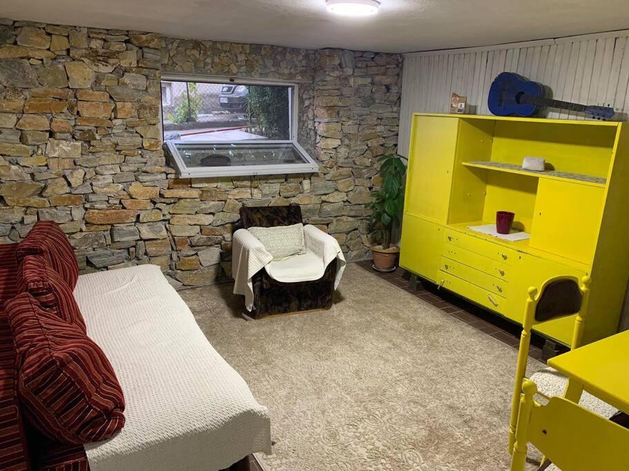una camera da letto con mobili gialli e un muro in pietra di Joy apartment a Gradsko