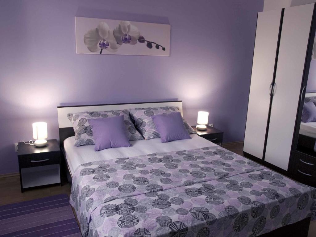 1 dormitorio con 1 cama con paredes de color púrpura y almohadas de color púrpura en Apartment Spalatina en Split