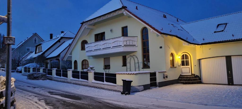 una casa blanca con techo cubierto de nieve en una calle en FeWo Giss, en Postbauer-Heng