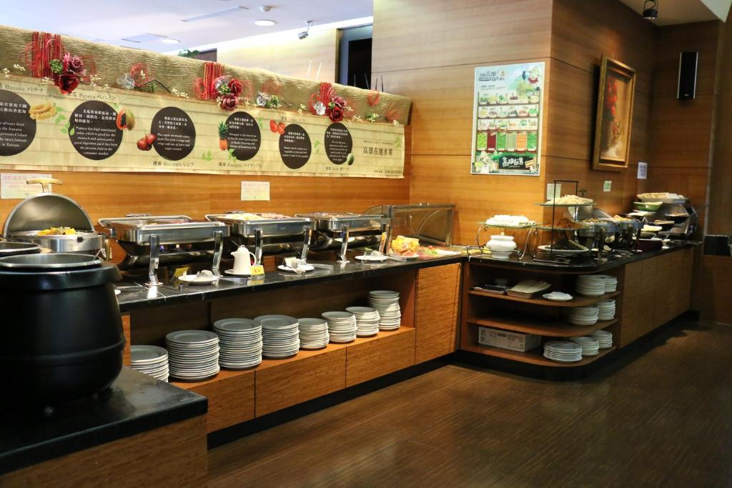 a restaurant with a counter with plates and food at King&#39;s Town Hotel in Kaohsiung