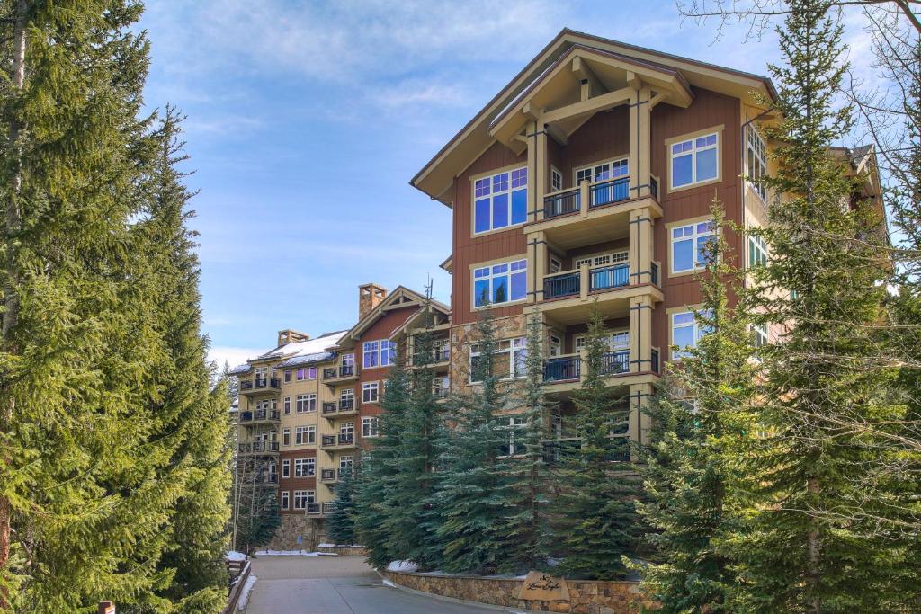 un grand immeuble d'appartements avec des arbres devant lui dans l'établissement Timbers & Lone Eagle by Keystone Resort, à Keystone