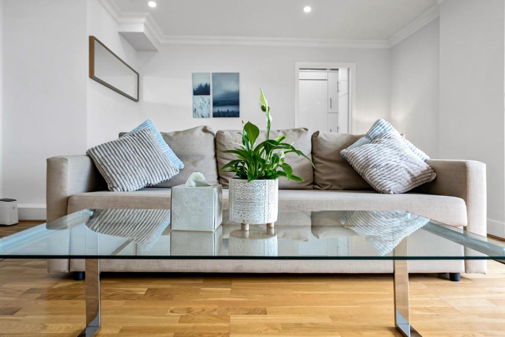 a living room with a couch and a glass coffee table at Stunning Flat on King's Road, Chelsea with Balcony in London