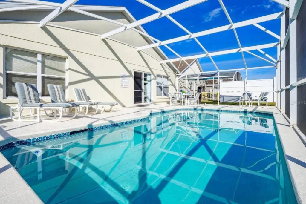a swimming pool with blue water in a house at Spacious Vacation Home Near Disney w/ Private Pool- Perfect for Families! in Davenport