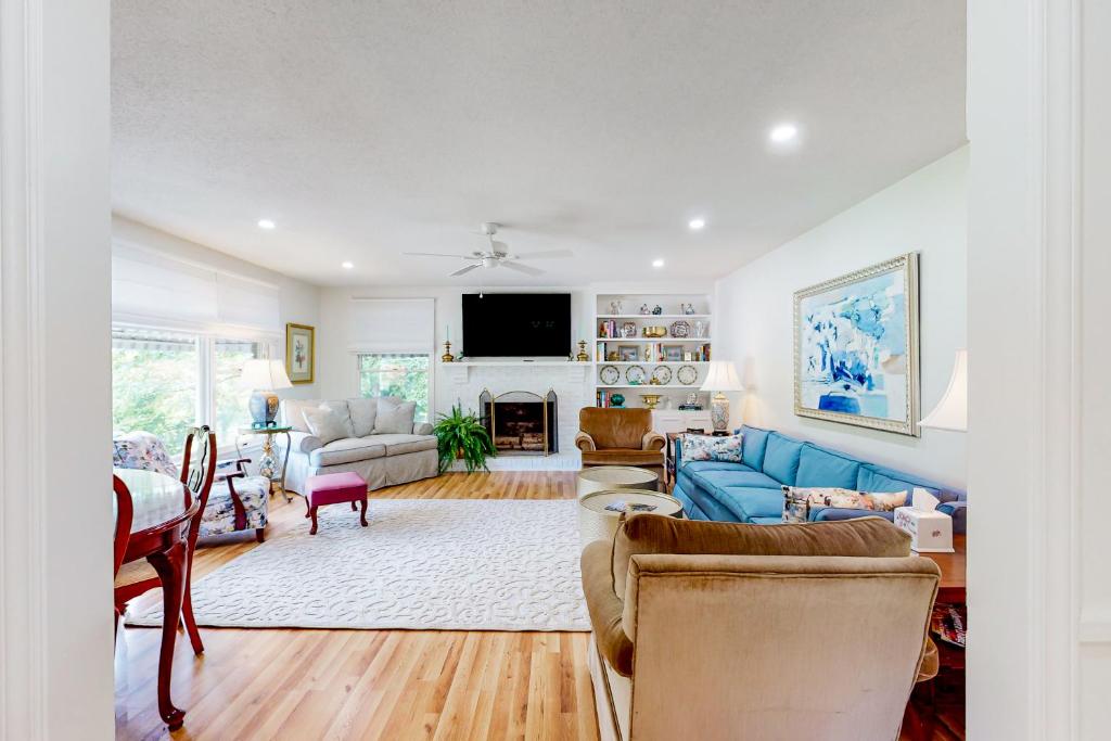 sala de estar con sofá azul y chimenea en Blue Ridge Cottage, en Waynesville